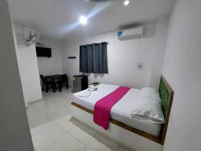 a bedroom with a bed with a pink blanket on it at Postel bar hotel in Cartagena de Indias