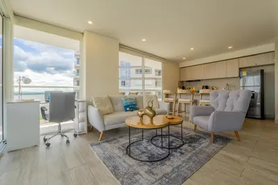a living room with chairs and a table and a kitchen at Dominique 1101 - Espectacular Apto con Jacuzzi in Cartagena de Indias