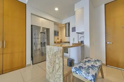a large kitchen with a counter and a refrigerator at New Apartment With 1 Bedroom In H2 in Cartagena de Indias