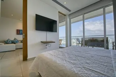 a bedroom with a large bed with a television on the wall at New Apartment With 1 Bedroom In H2 in Cartagena de Indias