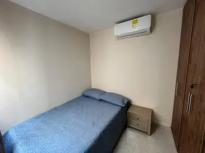 a small bedroom with a blue bed and a air conditioner at Hermosa casa con parqueadero en excelente ubicación in Barranquilla
