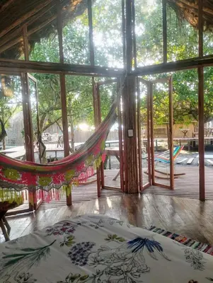 a hammock in a room with a large window at Eywa Lodge in Pueblo Coco