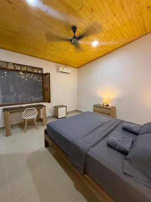 a bedroom with a large bed and a tv at Cabaña OtraParte in Rincón