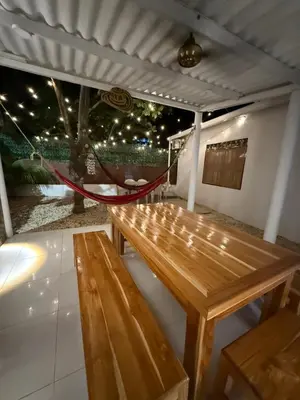 a wooden bench on a patio with a hammock at Cabaña OtraParte in Rincón