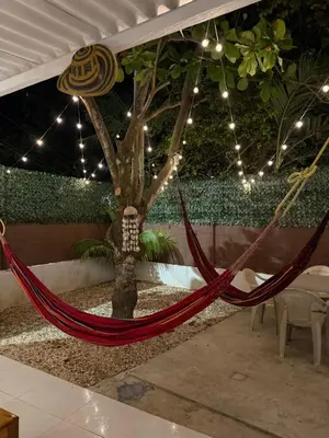a hammock tied to a tree in a courtyard at Cabaña OtraParte in Rincón