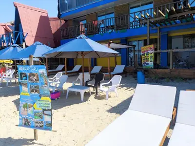 a sign on the beach with chairs and umbrellas at Hotel Miramar Baru in Playa Blanca