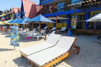 a group of chairs and umbrellas on a beach at Hotel Miramar Baru in Playa Blanca
