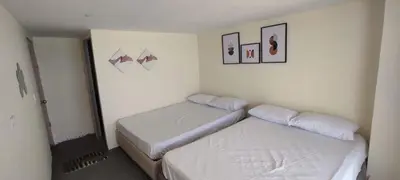 a bedroom with two beds and two pictures on the wall at Hotel Miramar Baru in Playa Blanca