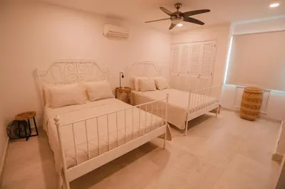 a bedroom with two beds and a ceiling fan at Caribbean Beachfront Getaway in Cartagena de Indias
