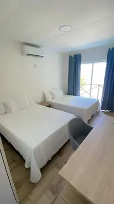 a hotel room with two beds and a window at Casa Mar in Puerto Colombia