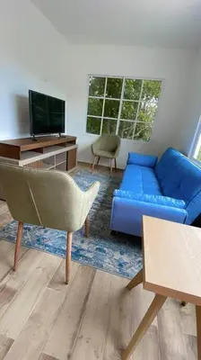 a living room with a blue couch and a tv at Casa Mar in Puerto Colombia