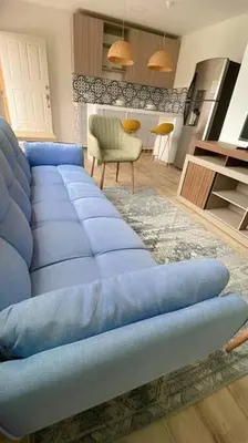 a living room with a blue couch and a kitchen at Casa Mar in Puerto Colombia