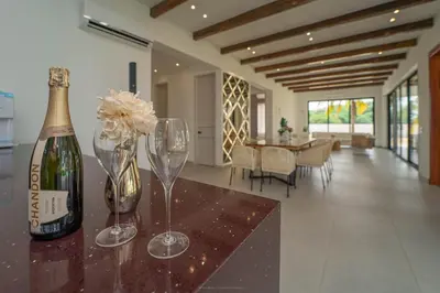 a bottle of champagne and two wine glasses on a counter at Villa de lujo frente al mar en Tierra Bomba in Cartagena de Indias