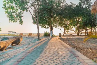 a woman walking down a brick path on the beach at Villa de lujo frente al mar en Tierra Bomba in Cartagena de Indias