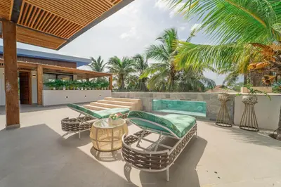 an outdoor patio with rattan chairs and a table at Villa de lujo frente al mar en Tierra Bomba in Cartagena de Indias