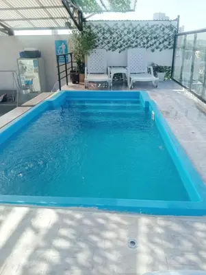 a large blue swimming pool with chairs in a building at Hostel AC in Cartagena de Indias