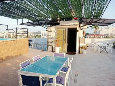 a patio with a glass table and chairs on a roof at Hostel AC in Cartagena de Indias