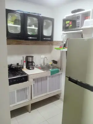 a small kitchen with a sink and a refrigerator at Hostel AC in Cartagena de Indias