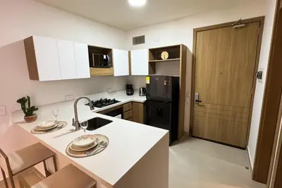 a kitchen with a white counter and a black refrigerator at BaiaKristal - Kabo en Cartagena in Cartagena de Indias