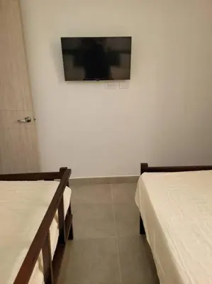a room with two beds and a tv on the wall at Refugio de ensueño in Manzanillo del Mar