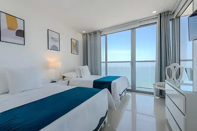 a hotel room with two beds and a large window at Panoramic Sea View & Historic Center “Morros City” in Cartagena de Indias