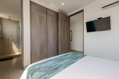 a bedroom with a bed and a tv on a wall at Panoramic Sea View & Historic Center “Morros City” in Cartagena de Indias
