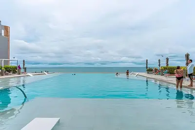 a swimming pool with people walking in the water at Panoramic Sea View & Historic Center “Morros City” in Cartagena de Indias