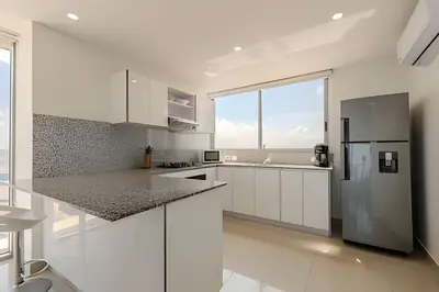 a kitchen with white cabinets and a large window at Panoramic Sea View & Historic Center “Morros City” in Cartagena de Indias