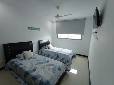 a room with two beds and a television in it at Descanso frente al mar in Cartagena de Indias