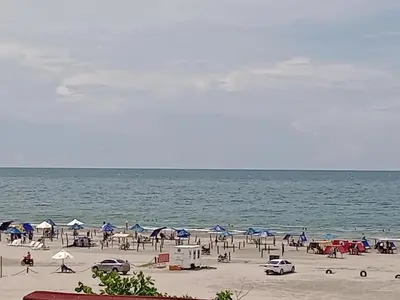a beach with chairs and umbrellas and the ocean at Descanso frente al mar in Cartagena de Indias
