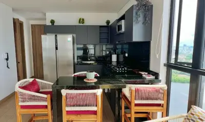 a kitchen with a counter with chairs and a table at Luxury Murano Cartagena Condo in Cartagena de Indias