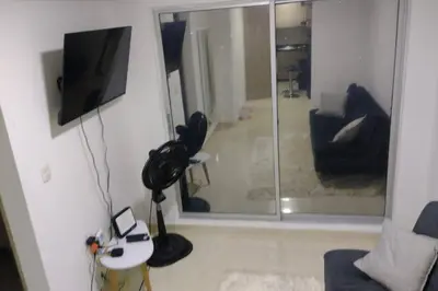 a living room with a tv and a glass door at CARTAGENA CONFORT APARTAMENTO NUEVO y COMPLETO in Cartagena de Indias
