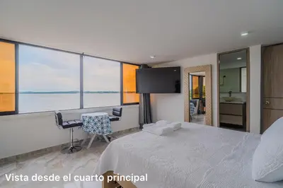 a bedroom with a bed and a desk and a tv at lujoso apartamento familiar frente al mar in Cartagena de Indias