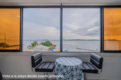 a table and chairs in a room with a view of the water at lujoso apartamento familiar frente al mar in Cartagena de Indias