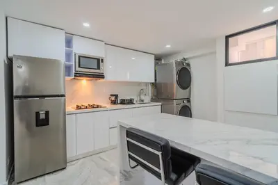 a kitchen with white cabinets and a stainless steel refrigerator at lujoso apartamento familiar frente al mar in Cartagena de Indias