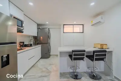 a kitchen with a counter and two bar stools at lujoso apartamento familiar frente al mar in Cartagena de Indias
