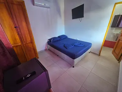 a small bedroom with a bed and a television at Cabaña Sol y Mar 2 in Coveñas