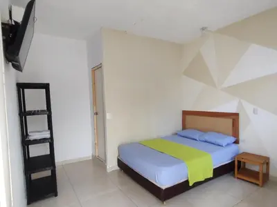 a bedroom with a bed with a yellow and blue blanket at casa Marez in Cartagena de Indias