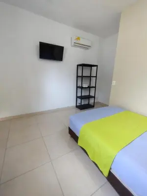 a bedroom with a bed with a green blanket at casa Marez in Cartagena de Indias