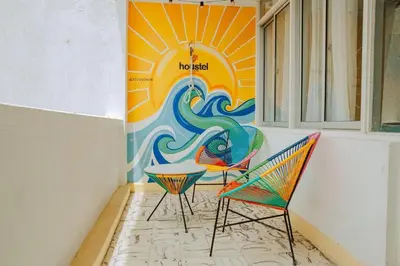 a room with two chairs and a table and a mural at Laguito Houstel Large in Cartagena de Indias