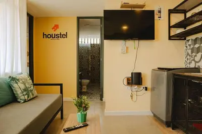 a living room with a couch and a television on the wall at Laguito Houstel Large in Cartagena de Indias