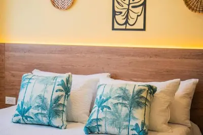 a bed with blue and white pillows and a wooden headboard at Laguito Houstel Large in Cartagena de Indias