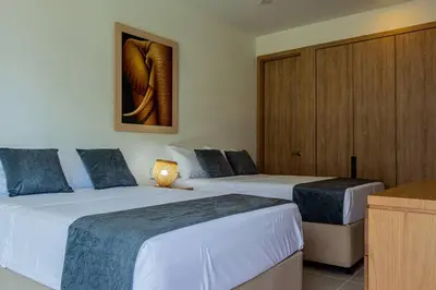 a hotel room with two beds and a cabinet at APARTAMENTO EN CARTAGENA CON SALiDA DIRECTA A LA PLAYA in Cartagena de Indias