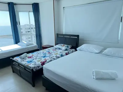 a bedroom with two beds and a large window at Apartamento con vista al mar in Cartagena de Indias