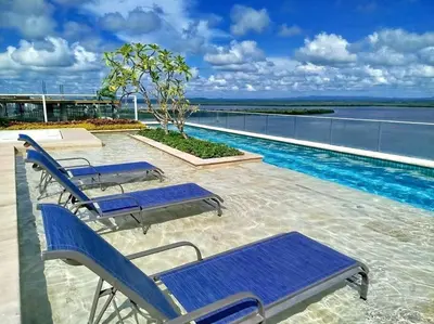 a swimming pool with blue chairs and the water at Cartagena Martinique - Hermoso apartamento con Jacuzzi en el Balcón! in Cartagena de Indias