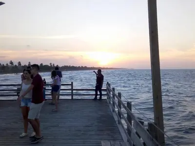 a group of people standing on a pier near the water at Cabaña Olas Del Mar in San Bernardo del Viento