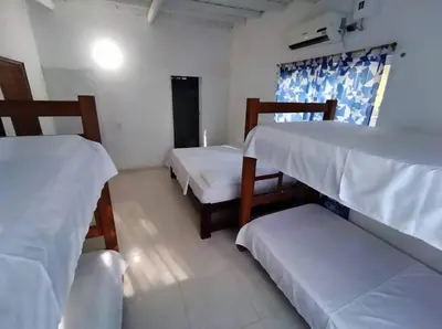 a room with two bunk beds and a couch at Cabaña Olas Del Mar in San Bernardo del Viento