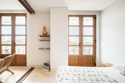 a bedroom with a bed and two windows at Sunny new apt in the Old City in Cartagena de Indias