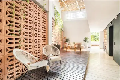 a room with two chairs and a wall with plants at Sunny new apt in the Old City in Cartagena de Indias
