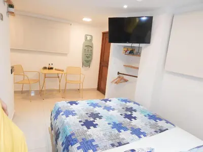 a bedroom with a bed and a table with chairs at Studio Nurita Boston in Barranquilla